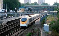 A July evening in 2005 at Kensington Olympia with a 'eurostar' working wrong-line back to North Pole depot past a freight held on the centre road. The building in the background with the blue roof once housed the former Motorail loading bays - now Olympia Parking!<br><br>[John Furnevel 20/07/2005]
