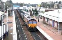 Imported coal from Hunterston import terminal, heading for Longannet power station via the Forth Bridge, rumbles east through Falkirk Grahamston station on New Years Eve 2004. The locomotive is EWS 66157.<br><br>[John Furnevel 31/12/2004]