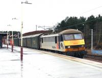 A lengthy train of wet containers speeds south through a wet Carstairs past a wet photographer on a wet December day in 2004. The wet locomotive is Freightliner 90049.<br><br>[John Furnevel 02/12/2004]