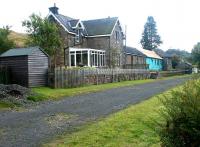 The trackbed of the Border Counties Railway through Falstone looking south towards Bellingham in September 2003. The former station master's house is nearest the camera, with the stone signal box at the far end. The whole site is currently undergoing refurbishment and conversion for use as holiday accommodation.<br><br>[John Furnevel 24/09/2003]