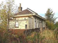 Longmorn former Station. Platform side looking north. Building is in good condition, platform heavily overgrown, building on southbound platform burnt down. 14/10/05.<br><br>[John Gray 14/10/2005]