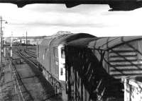 Freights about to cross at Thornton Junction in 1971. BRCW Type 2 5322 runs under the footbridge of the closed station northbound, while an EE Type 1 has just joined the up main line at Thornton North Junction with a freight off the Fife Coast route. Mineworkings in the background are the remains of Balgonie Colliery (Julian Pit) which closed in 1960.<br><br>[John Furnevel 23/03/1971]