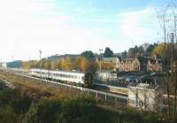 On a bright autumn morning in Nov 2003 a Wick/Thurso service pulls into Muir of Ord. The shed used when the line was cut at Inverness following the bridge collapse is in the left background [see image 16138] and the abandoned east side platform, used at one time by Fortrose branch trains is nearest the camera.<br><br>[John Furnevel 23/11/2003]