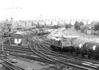 A Brush type 4 with a Freightliner is held at signals approaching Portobello East Junction off the sub in 1972. The train is standing below the bridge that carried the Lothian Lines on their way to Leith Docks. The Freightliner is waiting to cross the ECML and enter Portobello FLT, but the manoeuvre has been temporarily blocked due to the passing of an EE Type 3 with a train of tanks from Granton.<br><br>[John Furnevel 30/10/1972]