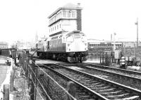 A pair of Type 2s running light over Camperdown level crossing, Dundee, in 1982. The locomotives will reverse into the cement terminal located behind the signal box. [See image 16149]<br><br>[John Furnevel 04/02/1982]