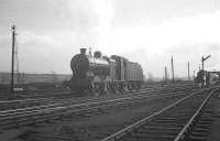 View south at Upperby in 1964, with Fowler 4F 0-6-0 no 44081 alongside its home shed. In the background a Stanier 8F is approaching with a down freight. [See image 32191]<br><br>[K A Gray //1964]