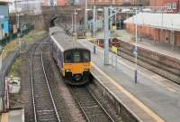Sprinter 150118 rolls into Altrincham on a Northern service from Chester to Piccadilly on 13th January 2015. The train is passing the Metrolink bay platforms, seen from the vantage point of the new <I>glass</I> footbridge. <br><br>[Mark Bartlett 13/01/2015]