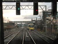 A Metrolink service departs for Manchester and the signal is immediately cleared for an inbound tram to enter Altrincham's Platform 1. The tracks on the left of the tram are the Network rail lines running through Platforms 3 and 4 and just ahead of the tram is the occasional use link between the two systems. <br><br>[Mark Bartlett 13/01/2015]