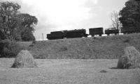 Another photograph (undated) showing a train on the embankment to the east of Kelso, [see image 50128]. This one features a steam hauled freight heading in the Tweedmouth direction behind a WD Austerity 2-8-0.   <br><br>[Bruce McCartney Collection //]