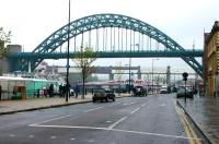 Sunday morning on a grey and wet Quayside in May 2006. The Tyne Bridge dominates, with the red and white Swing Bridge beyond. Partially clad in white for maintenance is the High Level Bridge, with the Tyne & Wear Metro Bridge visible through the piers. The King Edward Bridge stands beyond. The Quayside branch, once operated by Gresley's two class ES1 electric locomotives, arrived from Trafalgar Yard via a tunnel behind the camera. The branch closed in 1969 [see image 20118].<br><br>[John Furnevel 07/05/2006]
