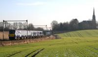 334001 on an Edinburgh Waverley - Helensburgh Central stopping service passes Bargeddie Parish Church on the approach to Easterhouse on 6 February 2015.<br><br>[Colin McDonald 06/02/2015]