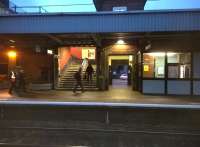 Still life with commuters. View across platform 1 and out through the main station entrance at Nuneaton Trent Valley station. A short branch line to a sawmill ran from right to left of this view a few yards beyond the white car in the background. [see image 35705]<br><br>[Ken Strachan 28/01/2015]