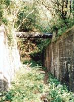 The far two tracks were on the Brecon and Merthyr line between Machen (right) and Hengoed (left). The solution to extending the bridge to support the tracks of the converging Barry Railway from Llanbradach viaduct [see image 33471] seems to have been to copy the existing brickwork. Some 46 years after closure of the B&M, and 73 years after the BR closure, the walls still support a water pipe. Off to the right the East end of Llanbradach viaduct has been demolished to make way for a quarry.<br><br>[Ken Strachan 31/05/2010]