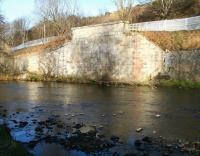 One mile south of the original Galashiels station a branch left the Waverley route and turned south west, crossing the Gala Water and running towards Selkirk. The surviving northern abutment of the railway bridge is seen here in February 2015, with the recently laid rails of what is now the Borders Railway running behind the metal fence. The Selkirk branch lost its passenger service in 1951, closing completely in 1964. [See image 48180] <br><br>[John Furnevel 08/02/2015]