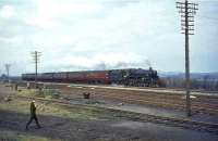 One of Eastfield shed's snowplough-fitted BR Standard class 5 4-6-0s, no 73108, about to run east through Bathgate Junction with an Edinburgh bound train on 30 March 1964. The background is provided courtesy of the West Lothian shale industry. Note the ex-LNER articulated coaches. (The wandering photographers had made a temporary escape from <I>Scottish Rambler No 3</I> during a photostop.)<br><br>[John Robin 30/03/1964]