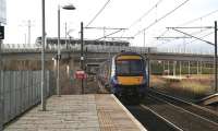 The 1330 Edinburgh Waverley - Glasgow Queen Street runs non-stop through Edinburgh Park on 18 February 2015 making for its next stop at Falkirk High. The train is about to pass below a tram crossing the flyover on its way to the airport. [See image 50421]<br><br>[John Furnevel 18/02/2015]