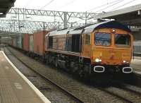 A shiny 66753 with white lined buffers thunders North through Bletchley with containers on a Friday afternoon in February 2015. Notice the viaduct in the background, waiting for its new platforms as part of the East-West Rail project.<br><br>[Ken Strachan 20/02/2015]