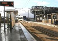 An eastbound Edinburgh tram comes off the bridge over Roseburn Street to reach the Murrayfield tram stop on 18 February 2015. At this point trams pass between Haymarket ScotRail depot and Murrayfied stadium. [See image 40638]<br><br>[John Furnevel 18/02/2015]