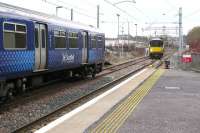 318259 leaves the turnback siding to enter Cumbernauld station on 5 March, prior to working a service to Dalmuir via Motherwell, Hamilton, Glasgow Central Low Level and Yoker. Timed to depart 4 minutes later, 320307 is waiting to perform a similar manoeuvre but will reach Dalmuir 20 minutes sooner via Springburn (reverse) and Glasgow Queen Street Low Level. <br><br>[Malcolm Chattwood 05/03/2015]