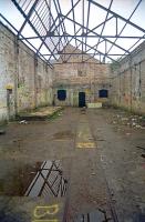 A narrow gauge line inside one of the disused buildings at Arniston in 2002. This site started with the Newbyres Pit, served by the Arniston Branch of the Marquis of Lothian's Waggonway. This was replaced by the Arniston Engine Pit and later by the Emily Pit (to the south) and the Gore Pit (beside the Waverley Route). Access to the system was by reversal at Gorebridge whereas the old waggonway approach was on the east side of the A7. The area is being progressively re-developed with housing.<br><br>[Ewan Crawford //2002]