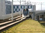 A city bound tram drops down from the E&G flyover towards the tram stop alongside Edinburgh Park station on 18 February 2015.<br><br>[John Furnevel 18/02/2015]