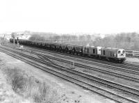 20175+20207 bringing a train of grain wagons into Millerhill Yard from the north in April 1981. Note the lifted track from the up yard stacked in the right background. <br><br>[John Furnevel 10/04/1981]