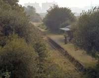 Looking south over Maentwrog Road station in 2002 towards the twin Magnox reactors of Trawsfynydd nuclear power station. Closed to passengers in 1960 and to all traffic a year later, the line was reopened from Blaenau Ffestiniog in 1964 to serve the new power station a mile to the south. It finally closed in 1998 following the decommissioning of Trawsfynydd. The station building at Maentwrog Road is now part of a private residence.<br><br>[Ewan Crawford //2002]