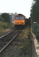 EWS 60039 draws its rake of covered 4 wheel MGR wagons through the overhead loading facility at Denby opencast loading point approaching the stop blocks in 1998. It will then push the wagons back through the loader to clear the points and allow the loco to run round and head back down the branch to the main line near Little Eaton. <br><br>[David Pesterfield 19/05/1998]
