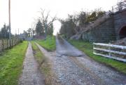 A view west up the approach to Evenwood station on 19 March 2015. The tarmac road would appear to have been added after the line closed in 1962 in order to provide easier access to the platform area.<br><br>[John McIntyre 19/03/2015]