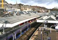 The 0833 Edinburgh - Dunblane runs into Stirling platform 2 on the morning of 1 April 2015. The red carpet beyond the train is part of an Abellio launch event to mark their takeover of the ScotRail franchise. At the top left of the picture Stirling Castle looks on impassively, having seen it all before.  <br><br>[John Furnevel 01/04/2015]