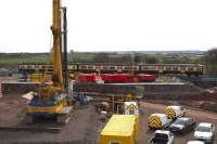 A Dalmuir to Whifflet service passes as steel reinforcing arrives at the Braehead viaduct construction site on 2nd April. Work is also in hand at this site to construct a road bridge which will carry Bredisholm Road over the motorway extension on the north side of the railway. An impressive collection of plant is now assembled on both sides of the line ready for the first of the weekend line closures in April 2015.<br><br>[Colin McDonald 02/04/2015]