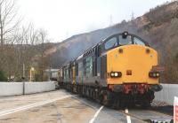 DRS 37607 and 37218 pile on the power as they start the climb out of Garve over the level crossing on 4 April 2015 with the 1Z69 Pathfinder Tour to Kyle of Lochalsh.<br><br>[John Gray 04/04/2015]