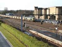 The 0613 Oxwellmains - Aberdeen Craiginches cement train about to run north through Stirling station on a bright and sunny morning on 1 April 2015. The locomotive is Freightliner 66618.<br><br>[John Furnevel 01/04/2015]