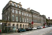 Opened in 1819 as the Waterloo Hotel, the building at 23 Waterloo Place was promoted as Edinburgh's 'first large scale hotel' with the strapline <I>'...an establishment where strangers can see the manners of the people and mix with the society of the place'</I>. The location was later to become, for many years, the Headquarters of the North British Railway Company. Now a category A listed building it has since reverted to its original use, this time under the name Apex Hotel, seen here on 14 April 2015. The Dugald Stewart Monument stands on Calton Hill in the right background.<br><br>[John Furnevel 14/04/2015]