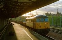 An evening 86/2 hauled freight southbound at Carstairs in 1989. At some stage the platform was raised and the building left in a 'trench' as can be seen to the left with a protective fence to protect passengers from falling in!<br><br>[Ewan Crawford //1989]