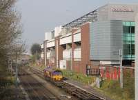 DBS 66124 runs through the platform line at Manchester United with a long rake of container flats from London Gateway. The train is approaching its Trafford Park destination, just beyond the next bridge. <br><br>[Mark Bartlett 24/04/2015]