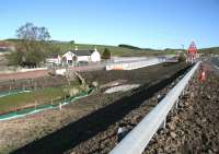 Looking north over the site of the former Heriot station on 26 April 2015. View is towards Edinburgh with the A7 and its associated roadworks on the right. The station building has now been demolished, the platform remains have gone and the old level crossing link with the village is no more [see image 4118]. Modern day pedestrian access is provided by a new DDA compliant underpass in the centre of the picture. Vehicle access from the A7 is via a new road with overbridge behind the camera. <br><br>[John Furnevel 26/04/2015]