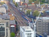 A train on the Southend line approaching Fenchurch Street station on 25 April 2015. On the right a Docklands Light Railway train is emerging from Tower Gateway station, with the entrance to the DLR tunnel to Bank visible alongside.<br><br>[John Thorn 25/04/2015]