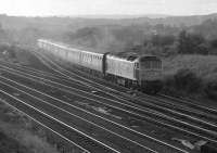 An early evening eastbound Trans-Pennine express, probably the 18:05 Liverpool - Leeds, comes off the Huddersfield line at Heaton Lodge East Junction behind an unidentified class 47 in the summer of 1983. The train is about to join the section of the Calder Valley line to Thornhill LNW Junction once controlled by the LMS speed signalling scheme of 1932.<br><br>[Bill Jamieson /07/1983]