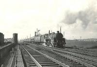 Standard class 5 73103 with a Largs - Glasgow St Enoch service on 4 April 1959. The train is passing the point where the L&A once crossed over the formation at Stevenston No 1.<br><br>[G H Robin collection by courtesy of the Mitchell Library, Glasgow 04/04/1959]