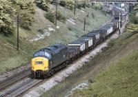 EE Type 3 No. 37 133 trundles southwards between Foxlow Junction (the base of the signalbox there is visible through the bridge at top right) and Barrow Hill in May 1974 with an LMR bound coal train - even the two five plank open wagons comprising the fitted head seem to be carrying this commodity.<br><br>[Bill Jamieson 30/05/1974]