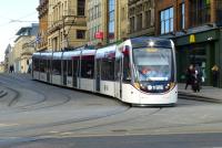 An Edinburgh Tram about to emerge from South St Andrew Street onto Princes Street on 25 March 2015. The angle gives a perspective on the overall length of these units.<br><br>[Colin Miller 25/03/2015]