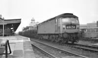 Brush Type 4 D1601 pauses at Cardiff General on a gloomy afternoon in March 1970 with a loaded milk train from west Wales to London. A class 08 shunter is either attaching or detaching vehicles at the rear.		<br><br>[Bill Jamieson 14/03/1970]