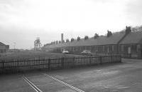 Looking south from the site of the Wemyss Coal Company/NCB level crossing over the A955 at East Wemyss in June 1983, with the headframe of the closed Michael Colliery in background. [For many years the rails were repeatedly covered by tarmac but have been left exposed in 2015.]     <br><br>[Bill Roberton /06/1983]