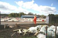 Warm work at Tweedbank station on 4 May 2015, with planting and landscaping being undertaken along the eastern perimeter of the site. View is west across the car park towards the station entrance.<br><br>[John Furnevel 04/05/2015]