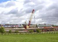 A Dalmuir - Motherwell service passes the construction site of the new M8 Bargeddie Viaduct on 11th May 2015. The line of old sleepers in the foreground shows the route of the former Tannochside branch of the Caledonian Railway.<br><br>[Colin McDonald 11/05/2015]