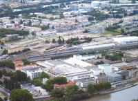 View over Grenoble from the Bastille in July 2014. The carriage sidings and servicing facility located immediately north of the main station, with what appear to be  Class X73500 diesel railcars, a TGV set and TER regional express sets awaiting their next turns. The X73500s work out of Grenoble on lines to Chambry via Montmlian,  Veynes and Gap, and Clelles. The circular building at the top right of the picture is the European Syncrotron, part of Grenoble's significant scientific research community.<br><br>[Andrew Wilson 07/07/2014]