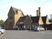 The architecturally impressive up side main building at Crewkerne, Somerset, looking south from Station Road in May 2015. The station is remote from Crewkerne itself, being some 2km from the town centre. A redundant signal box stands boarded up at the east (London) end of the up platform off to the left.[See image 51382]<br><br>[David Pesterfield 11/05/2015]