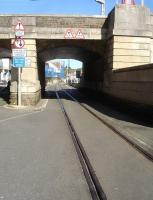 Looking east along Custom House Quay in May 2015, with the single track of the disused former Weymouth Tramway running under St. Edmunds Street overbridge on the approach to the moribund Harbour Station. [See image 48062]  <br><br>[David Pesterfield 12/05/2015]