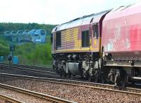 DBS 66067 has just taken the right fork at Larbert Junction on 20 May 2015 with a return empty working from Longannet power station to Hunterston coal import terminal. From here the train will drop down to Carmuirs West Junction before passing below the Forth and Clyde Canal. In the background a canal boat is about to enter the  upper gondola of the Falkirk Wheel on the Union Canal, prior to being lowered to the basin of the Forth and Clyde Canal 115 ft below. <br><br>[John Furnevel 20/05/2015]
